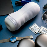 HUNG UFO Deep Space Male Trainer lying next to an iPad, watch, sunglasses and HUNG Hyrdo Lube Packets